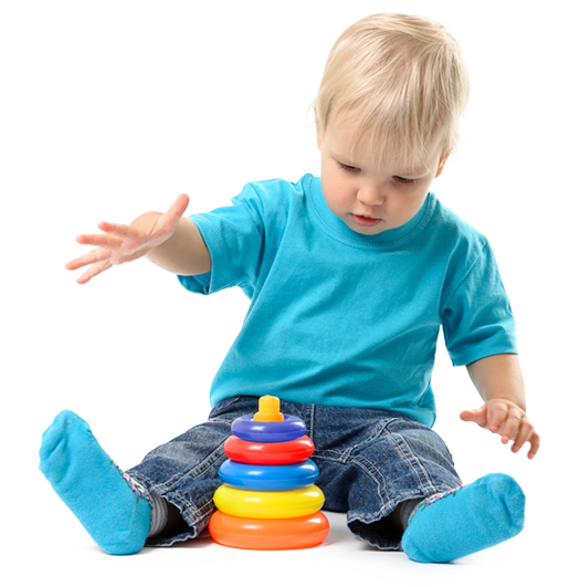 Toddler playing with a colorful ring stacker toy on the floor